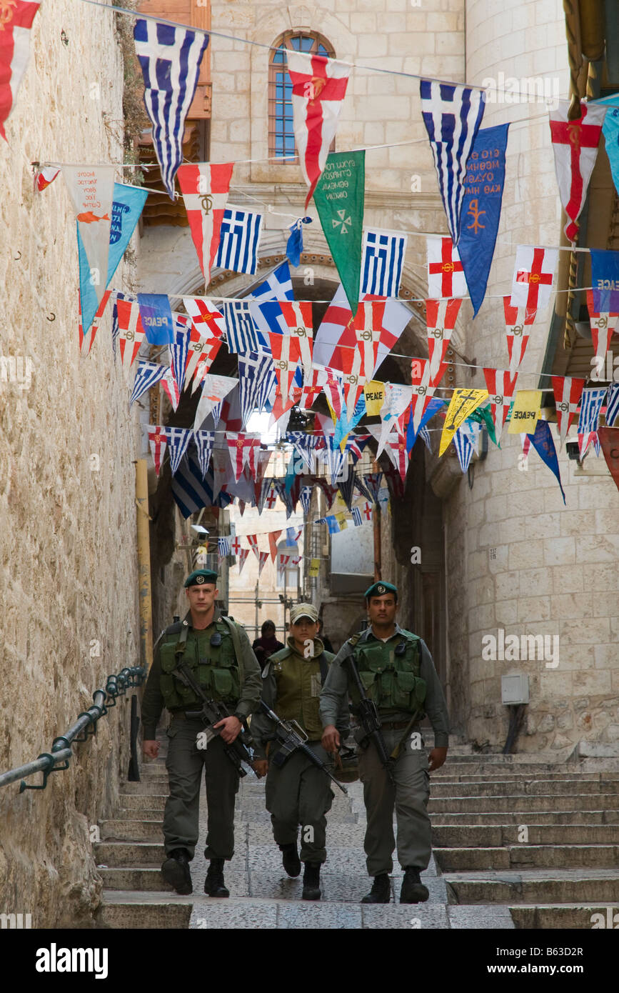 Israele Gerusalemme vecchia città patriarcato greco tre pattuglia di confine camminando per la strada sotto le bandiere Foto Stock