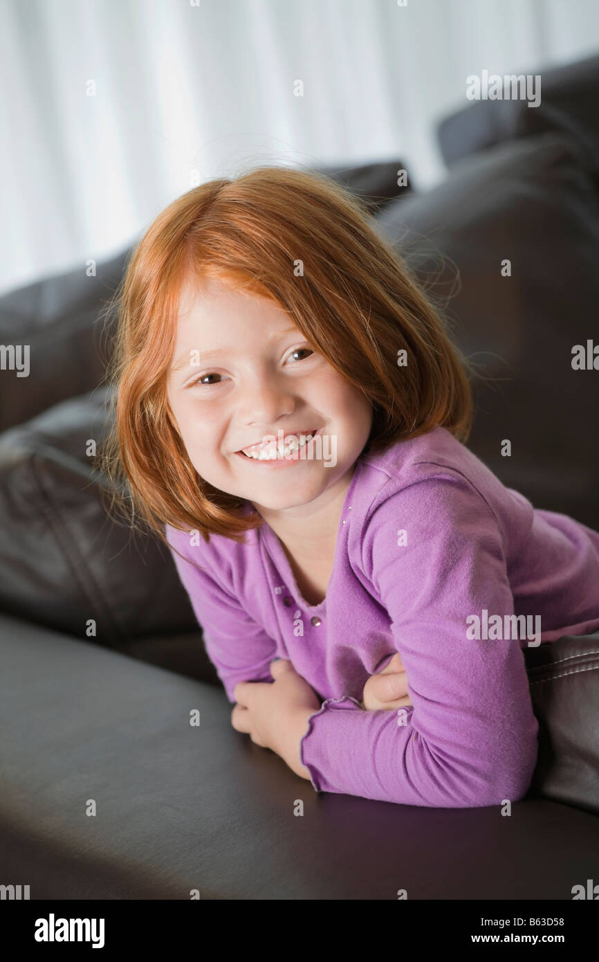 Ritratto di una ragazza appoggiata sul lettino e sorridente Foto Stock