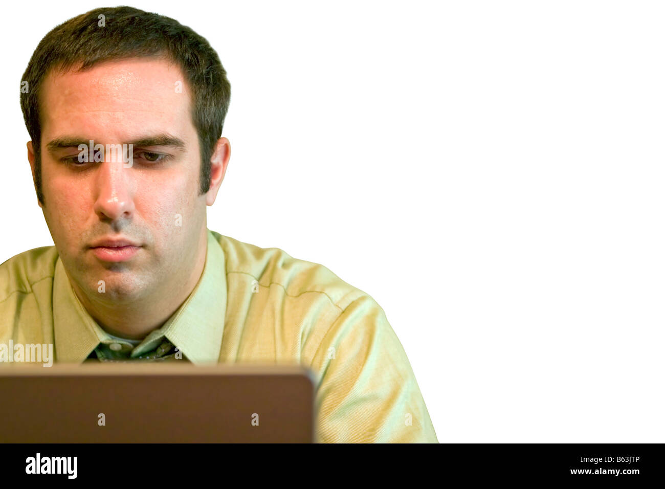 Un giovane uomo di affari di lavoro da casa sul suo laptop abbondanza di spazio copia immagine include tracciato di ritaglio Foto Stock
