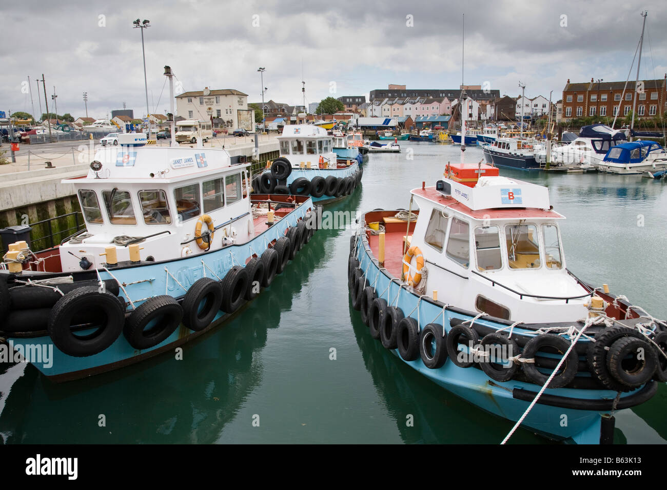 Rimorchiatore barche ormeggiate tra imbarcazioni da diporto nel Dock di campanatura, Portsmouth, Hampshire, Inghilterra. Foto Stock