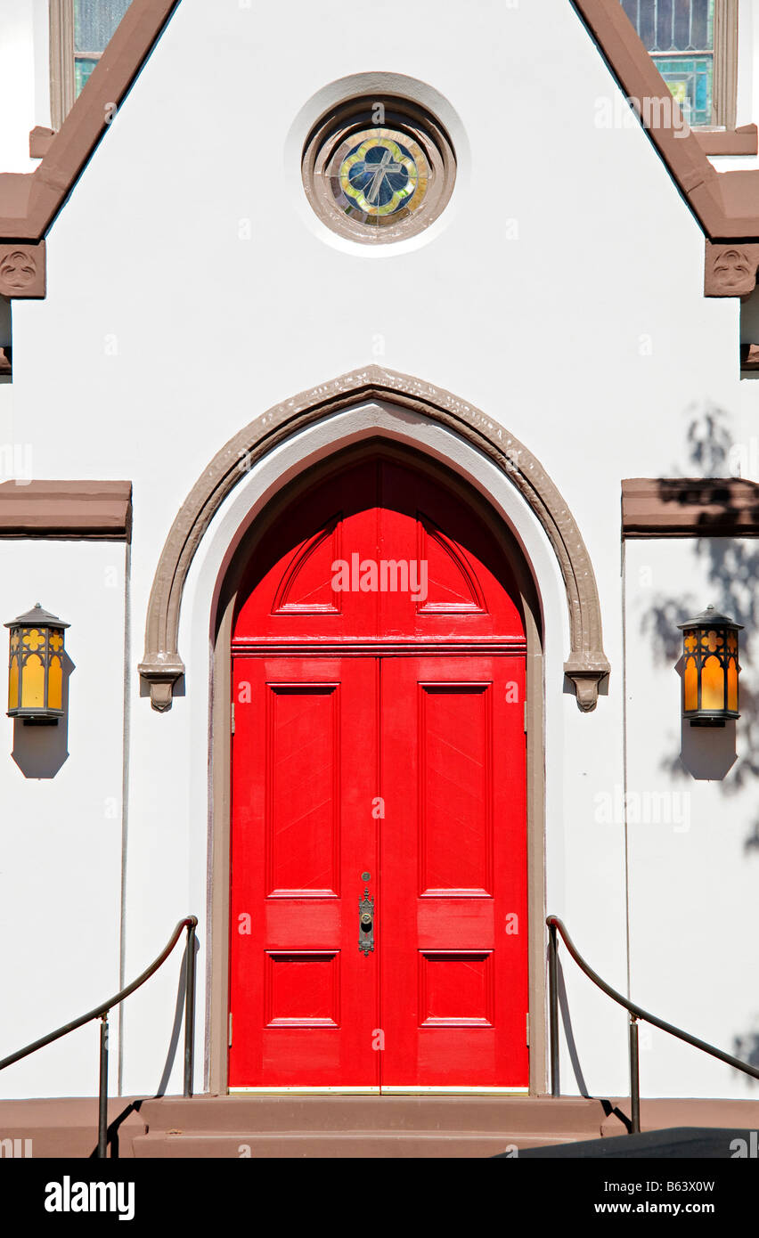 Chiesa evangelica luterana Red Door Frederick Maryland // FREDERICK, Maryland, Stati Uniti - l'ingresso principale con la sua caratteristica porta rossa segna la parte anteriore della Chiesa evangelica luterana nel centro di Frederick. Questa storica congregazione, fondata nel 1738, occupa un edificio architettonico significativo che presenta elementi neogotici e una robusta costruzione in pietra. La vibrante porta rossa, caratteristica comune in molte chiese luterane ed episcopali, simboleggia tradizionalmente il sangue di Cristo e segna il santuario come luogo di rifugio spirituale. Situato nel quartiere storico di Frederick Foto Stock