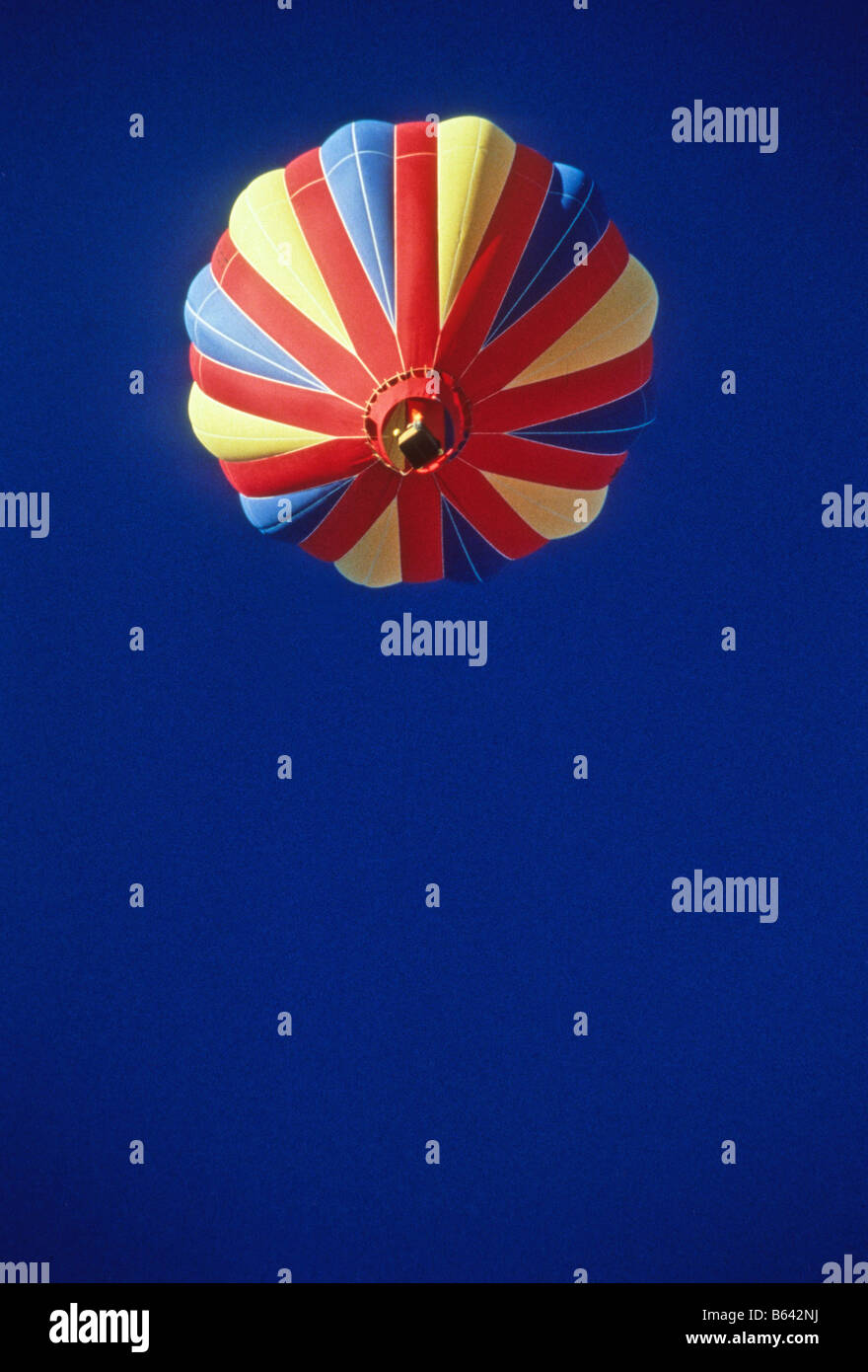 Coloratissima mongolfiera sorge nel cielo blu scuro, visto dal di sotto. Foto Stock