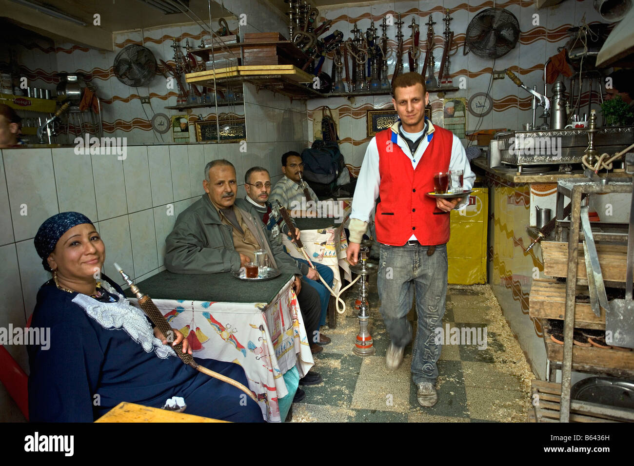 L'Egitto, al Cairo, caffè e tea shop. Donna e uomini fumatori waterpipe. Foto Stock