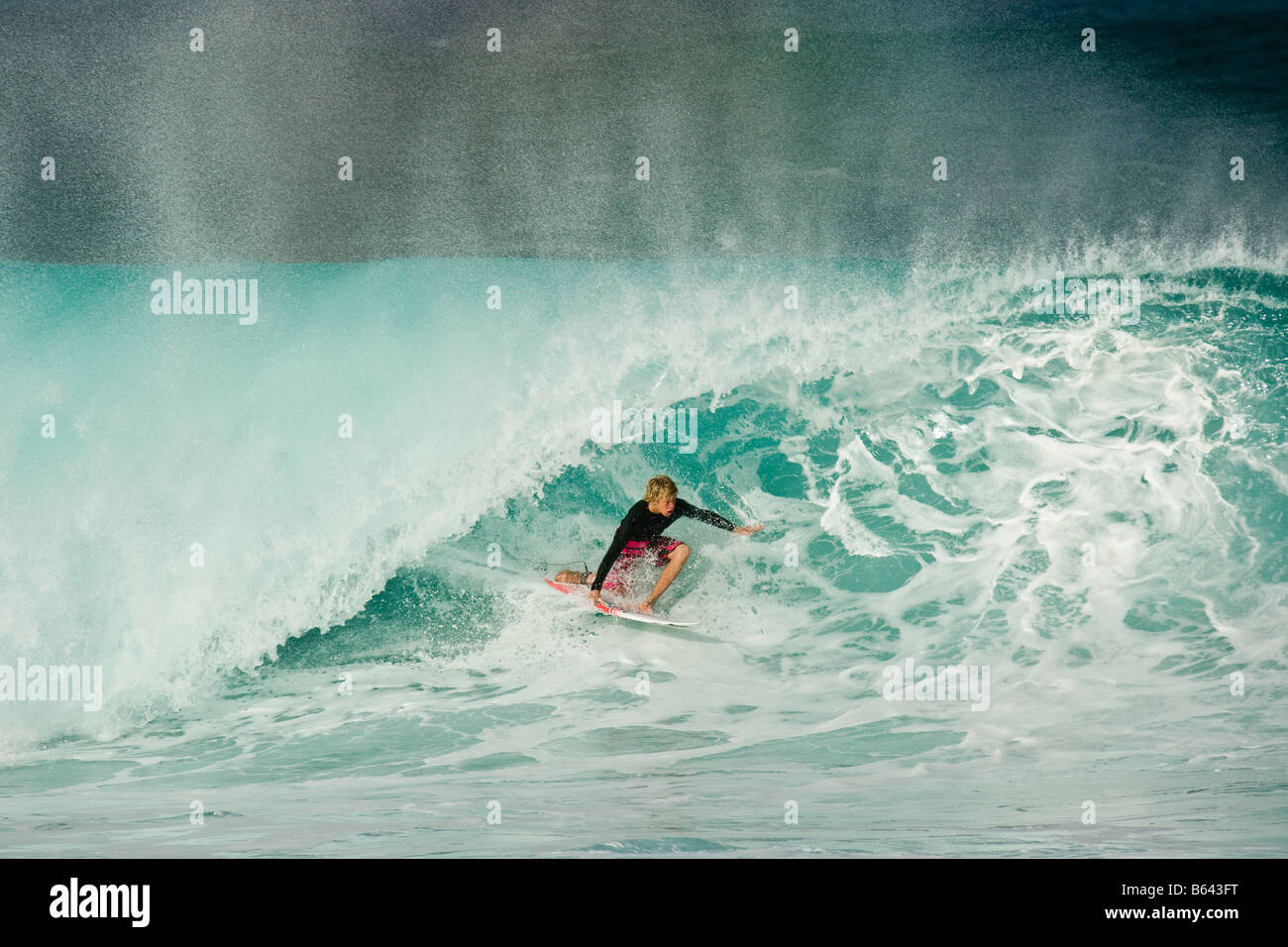 Surfer riding enorme ondata, Pipeline, North Shore Oahu, Hawaii Foto Stock