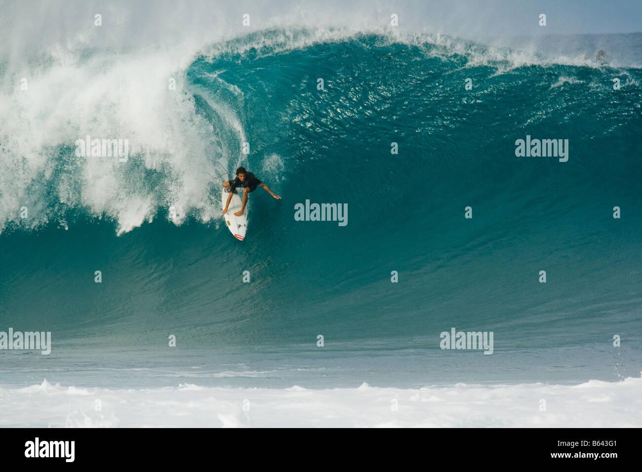 Surfer riding enorme ondata, Pipeline, North Shore Oahu, Hawaii Foto Stock