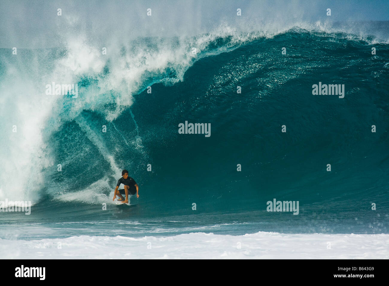 Surfer riding enorme ondata, Bonzai Pipeline, North Shore Oahu, Hawaii Foto Stock