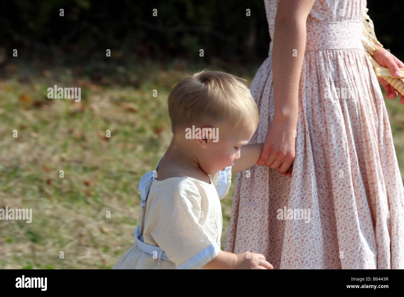 Una giovane ragazza tenendo le mani di un molto giovane ragazza toddler a una guerra civl rievocazione storica Foto Stock