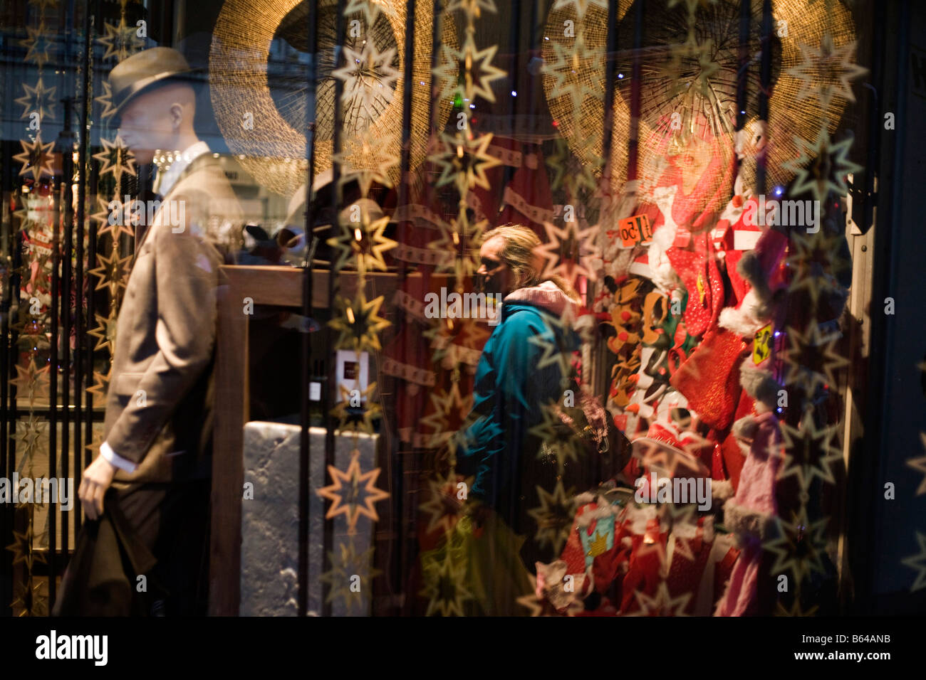 Un Christmas Shopper è visibile attraverso una finestra di Zara department store in Oxford Street Foto Stock