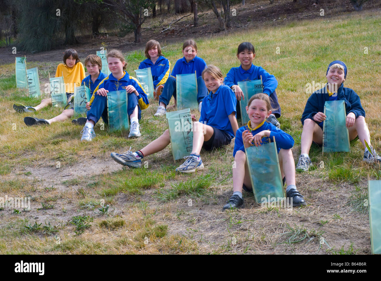 Tasmanian bambini della scuola primaria con un progetto di trapianto di alberi nella loro scuola Foto Stock