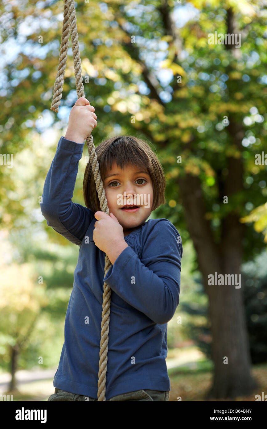 5 anno vecchia ragazza salendo una corda Foto Stock