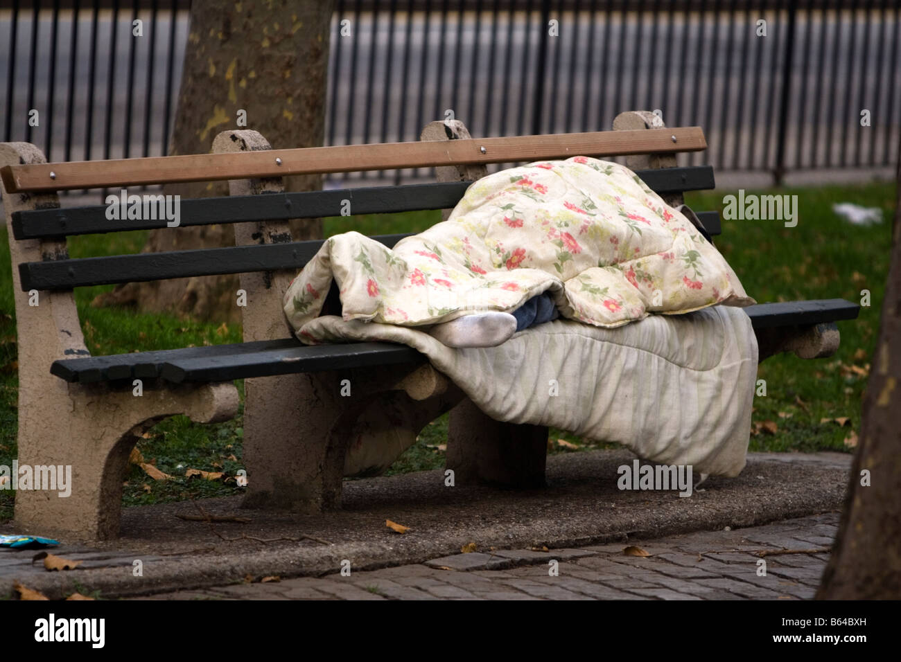 La persona senza dimora che dorme sul sedile nel parco. Brooklyn NY USA Foto Stock