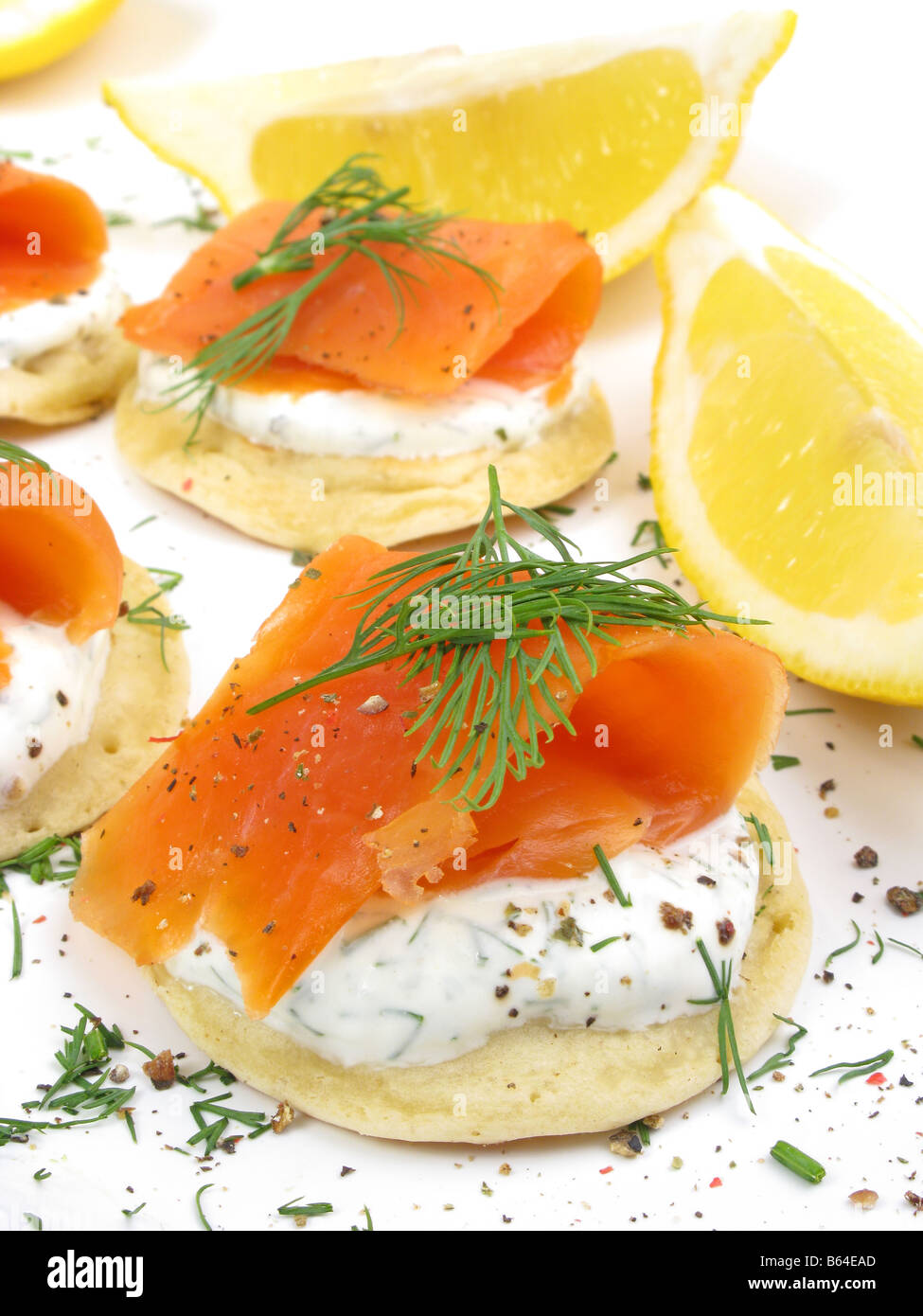 Crostini di Wild Alaskan Coho salmone affumicato su blinis, inacidito con panna e aneto. Foto Stock