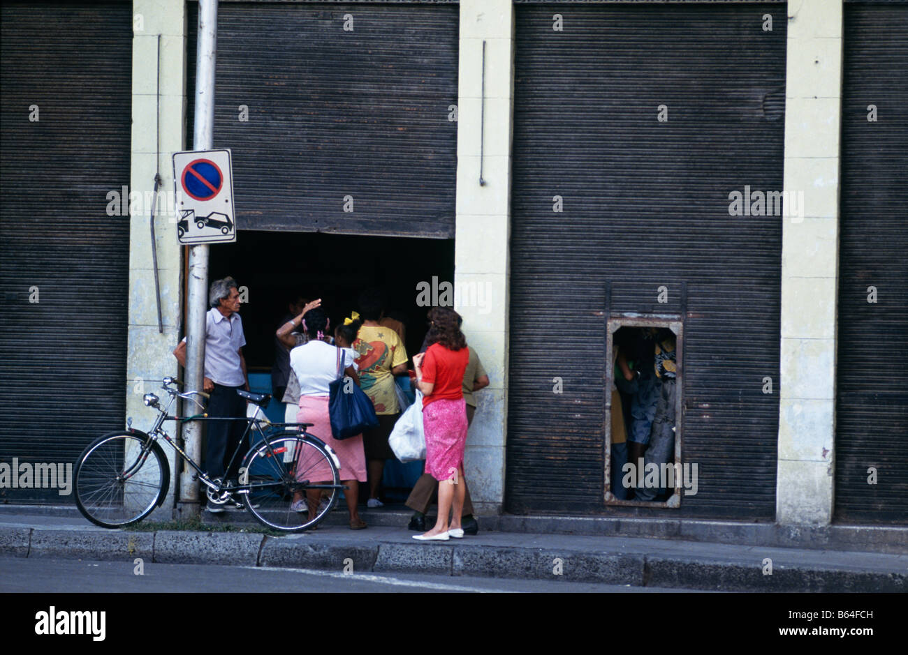 La gente in coda in entrata al negozio porta, Havana, Cuba 1993 Foto Stock