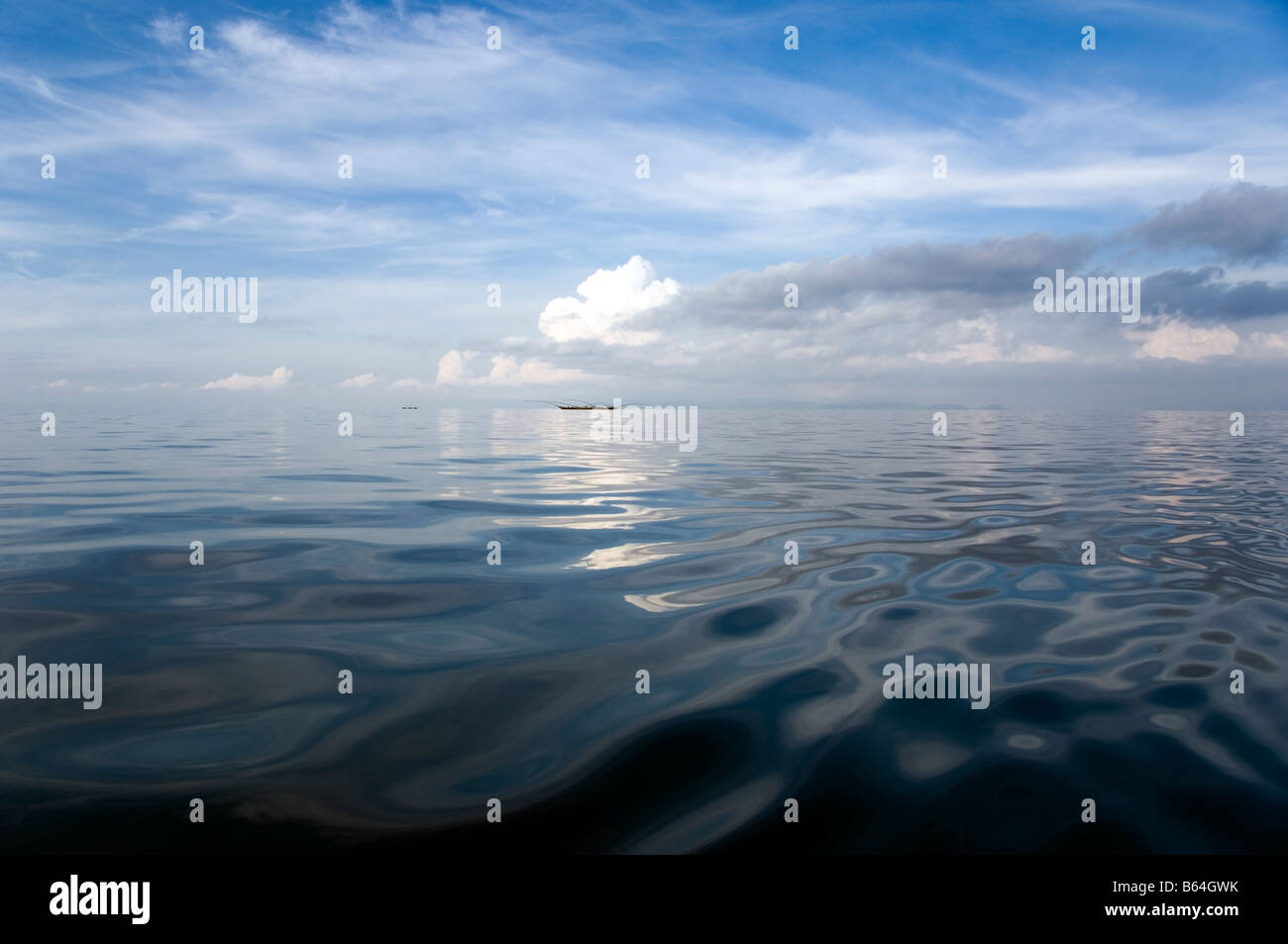 Livello acqua vista del lago Kivu in Ruanda in un giorno nuvoloso con esclusione di barche di pescatori sull'orizzonte Foto Stock