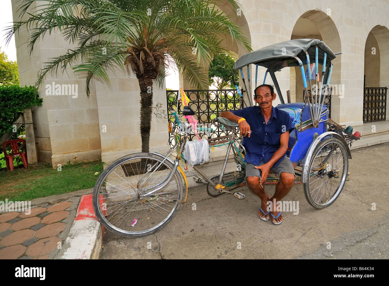 Risciò bicicletta (Thai Samlor) con driver al cimitero di guerra di Kanchanaburi, Thailandia Foto Stock