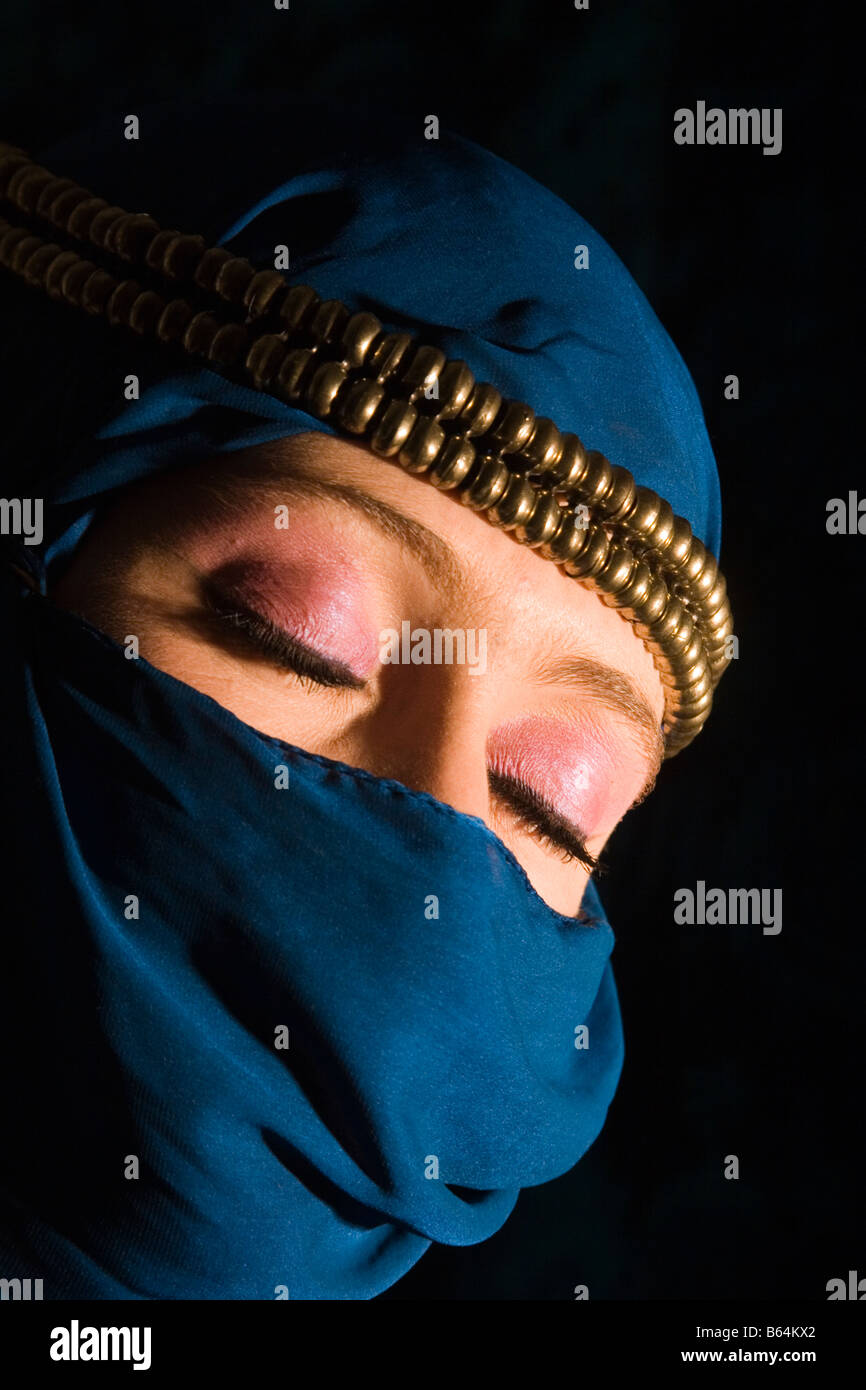 Giovane donna con headress decorativo e tipo yashmak velo che copre il volto Foto Stock