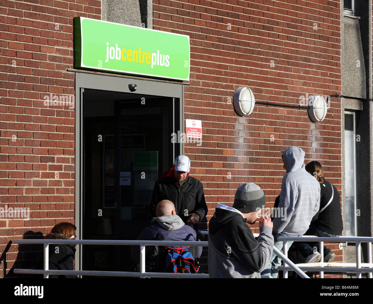 Persone in attesa al di fuori di un centro di lavoro Plus, Station Street, Nottingham, Inghilterra, Regno Unito Foto Stock