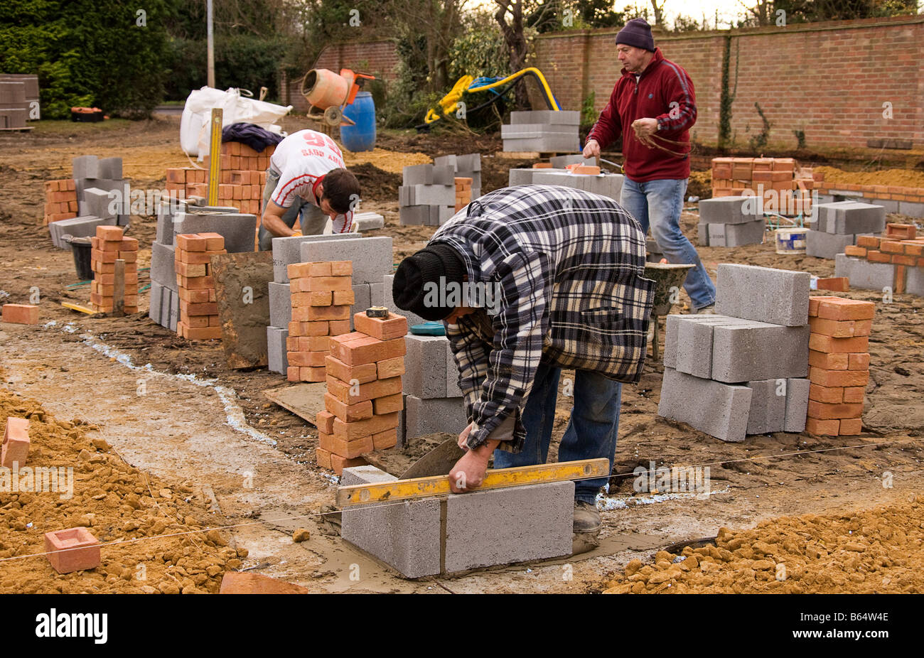 Controllo del livello dell'prima di blocchi in calcestruzzo di cui all'angolo di nuovi appigli con un livello di spirito. Foto Stock