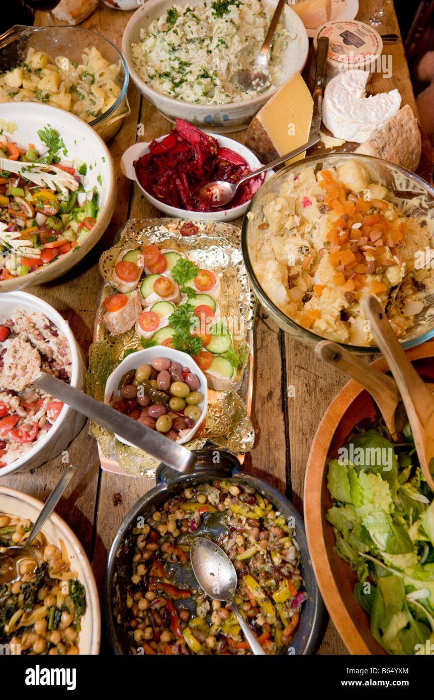 Tabella laden con molti piatti e piastre di insalate fresche e altri cibi sani in un party REGNO UNITO Foto Stock