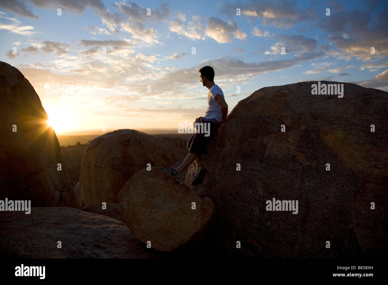Canyon Lodge Moment - l'uomo si appoggia sulla roccia guardando il tramonto Foto Stock