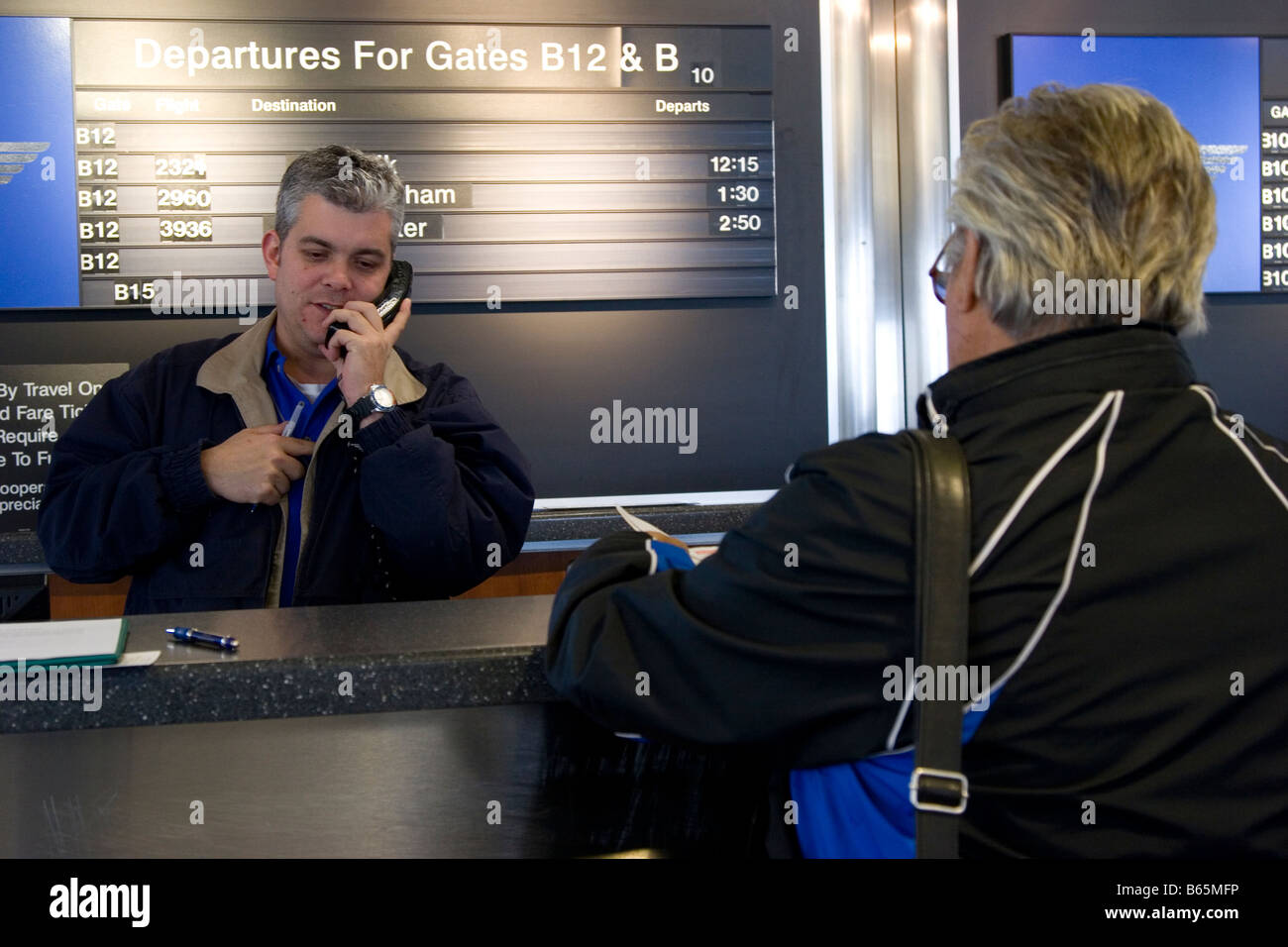 Compagnia aerea agente aiuta passeggero al banco per il check in all'aeroporto gate, Baltimore Washington International Airport, STATI UNITI D'AMERICA Foto Stock