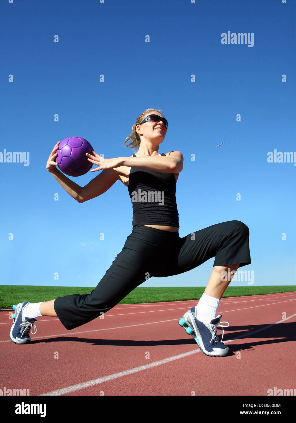 Giovane donna graziosa esercitando su una pista da corsa Foto Stock