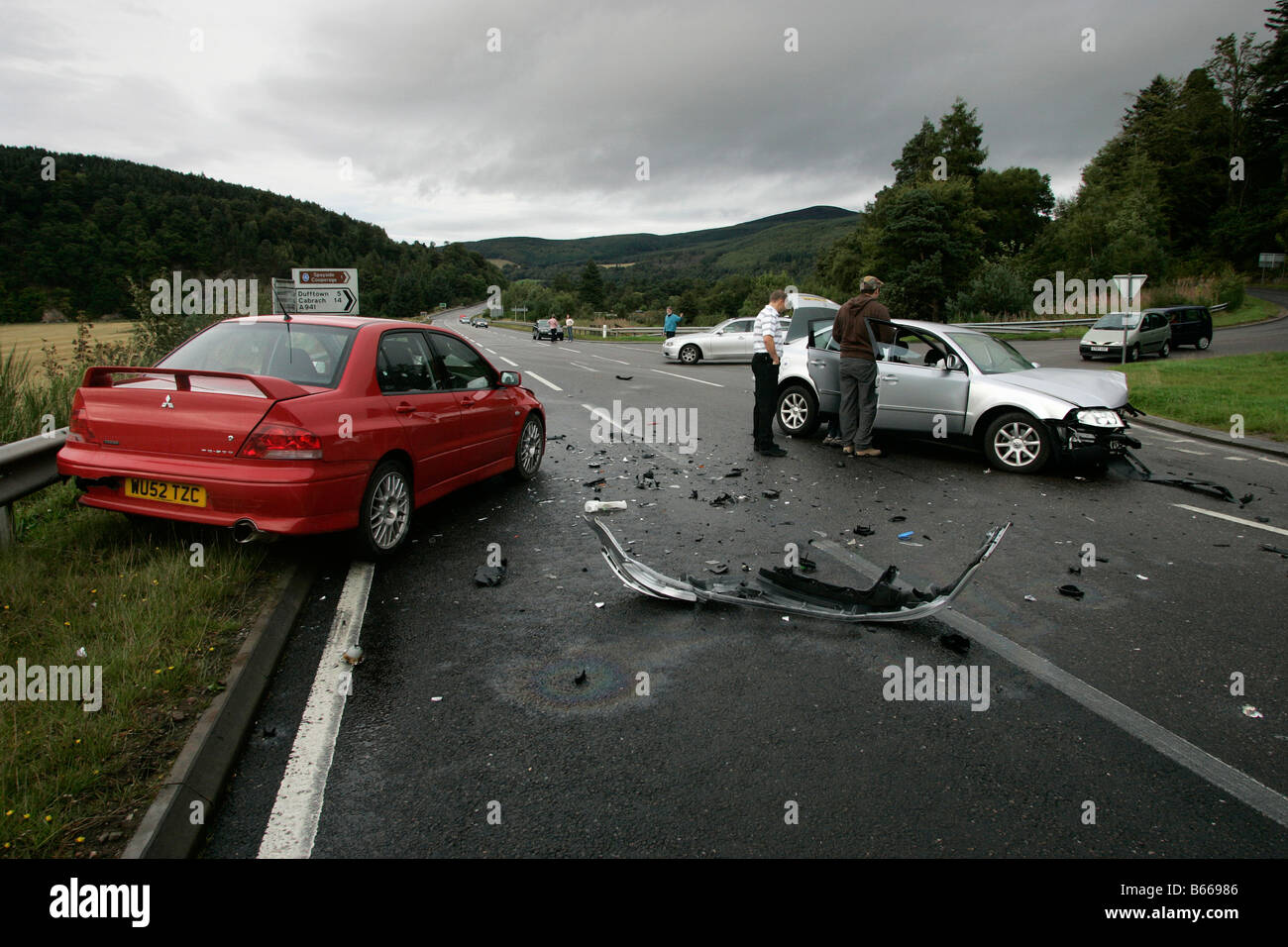 La scena di un incidente stradale che coinvolge una collisione frontale tra due vetture su una strada rurale in Scozia, Regno Unito Foto Stock