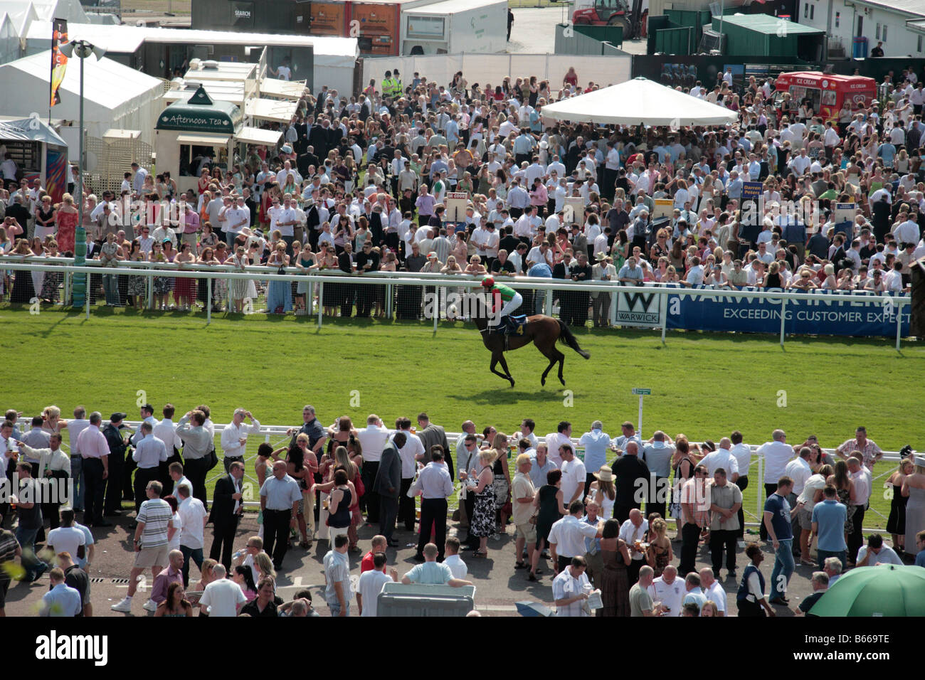 Chester Race Course, gara meeting, folla e cavalli in corso, in una giornata di sole, Cheshire, Inghilterra Foto Stock