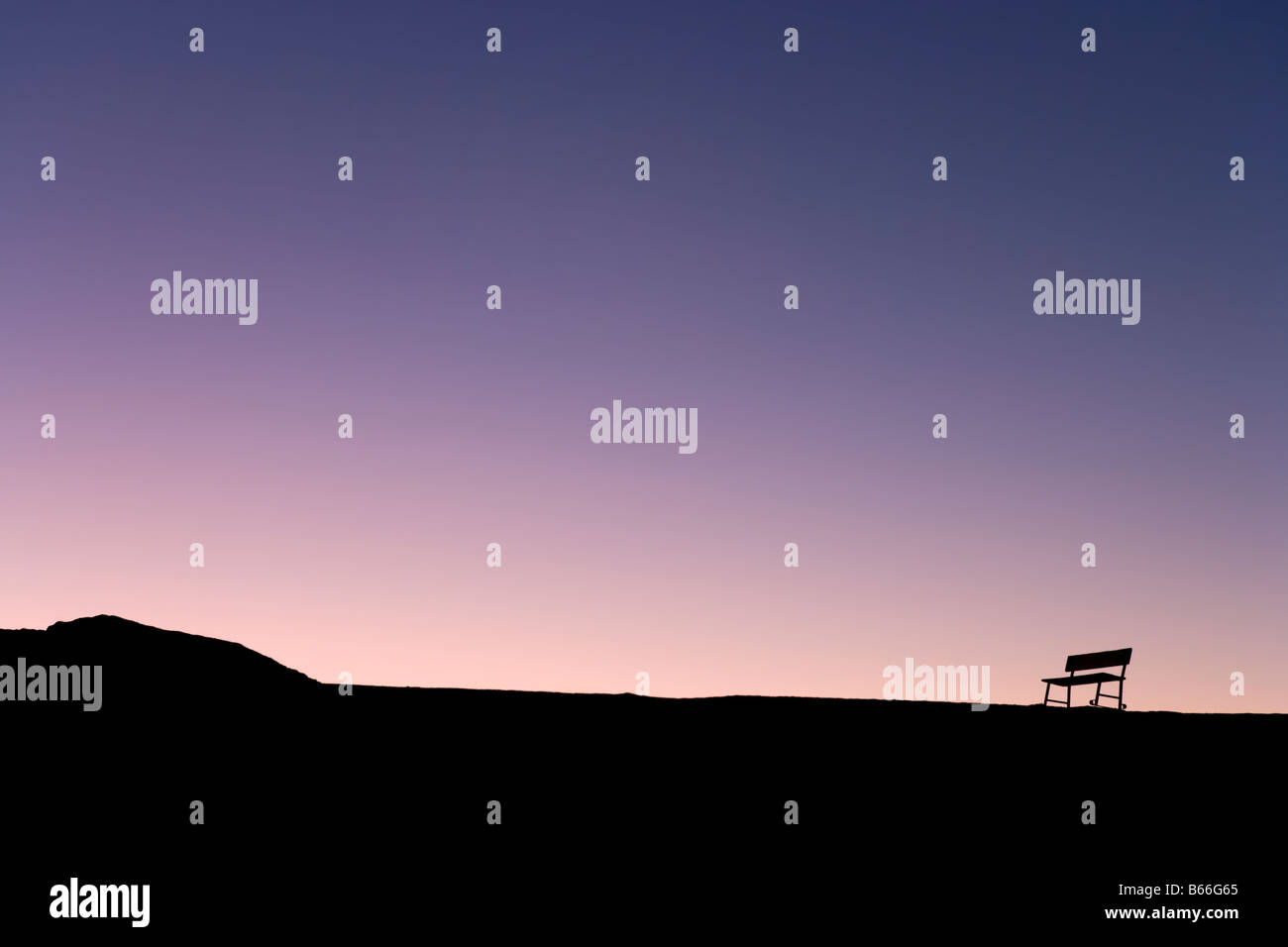 Silhouette di lone panca sulla skyline al tramonto, Zabriskie Point, Parco Nazionale della Valle della Morte, CALIFORNIA, STATI UNITI D'AMERICA Foto Stock
