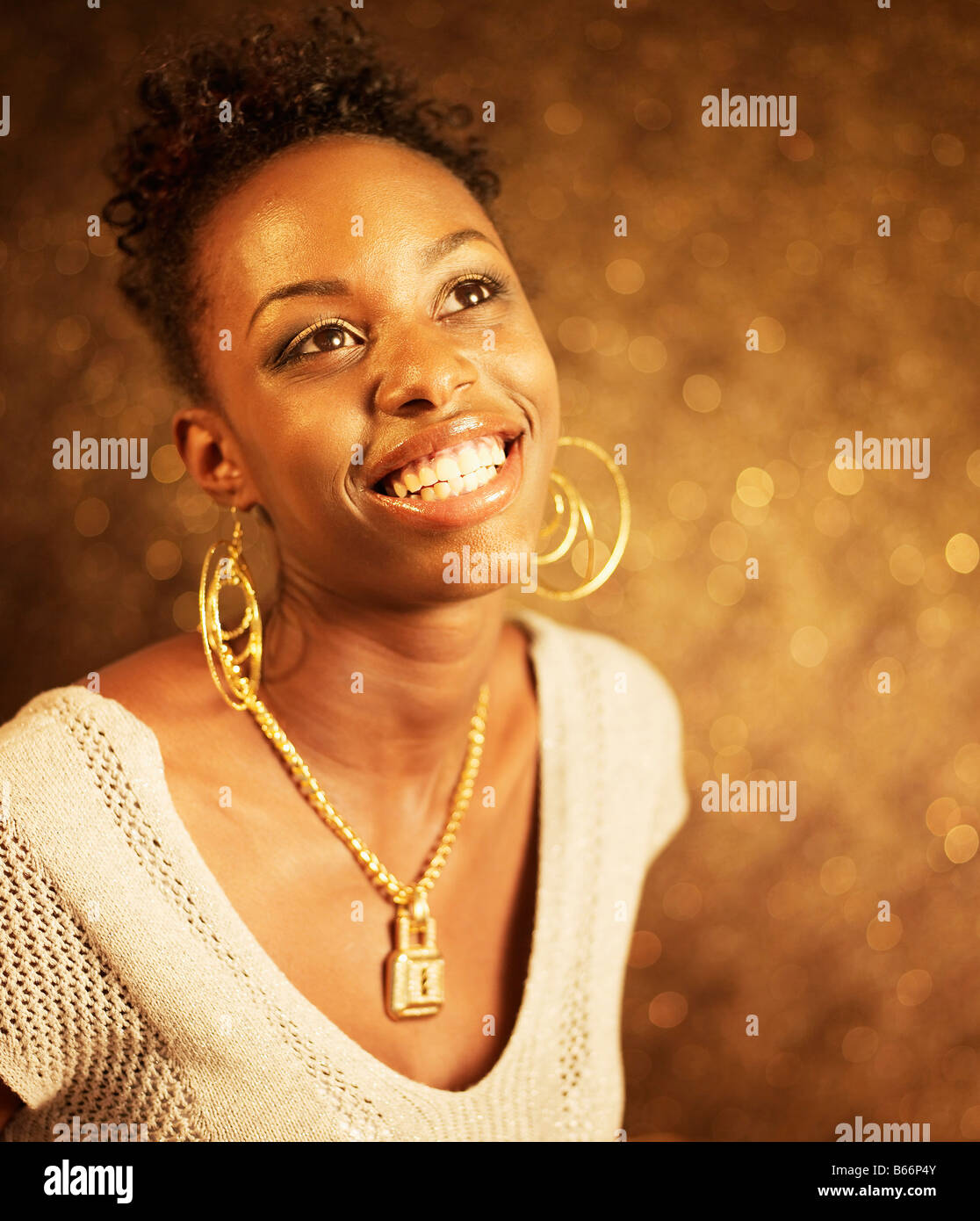 Felice giovane donna indossa gioielli in oro Foto Stock