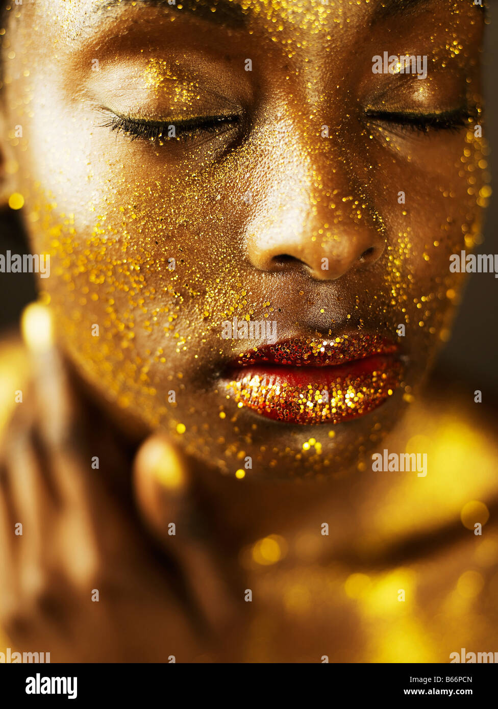 Giovane donna coperta in foglia oro Foto Stock