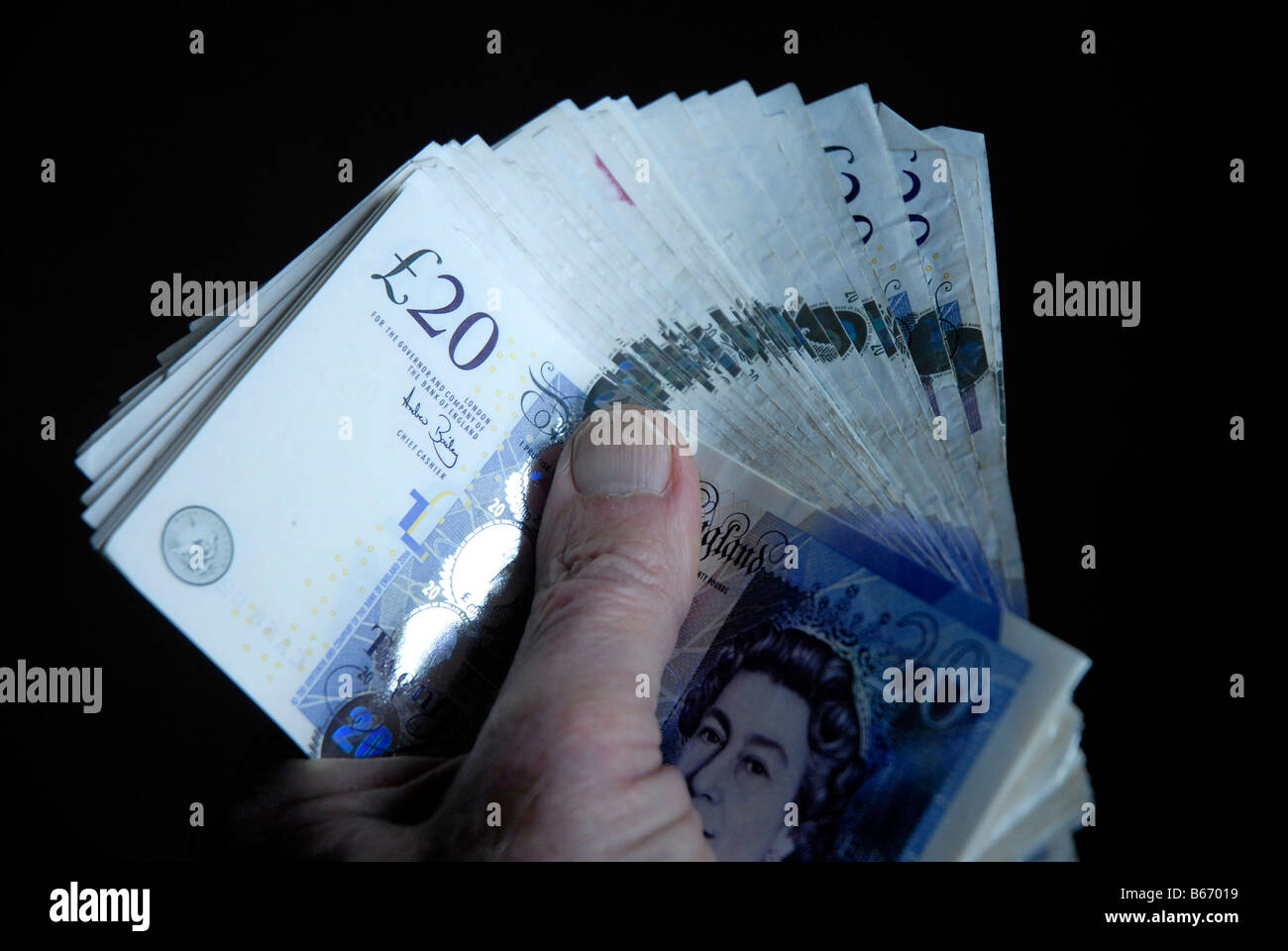 Manciata di inglese £20 note tenuta orizzontale in una forma a ventaglio Foto Stock