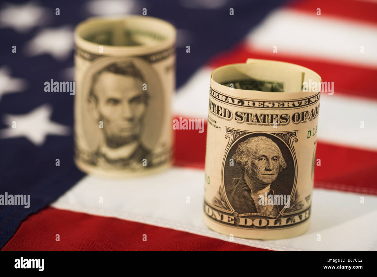 Un dollaro e cinque fatture del dollaro sulla bandiera americana, close-up Foto Stock