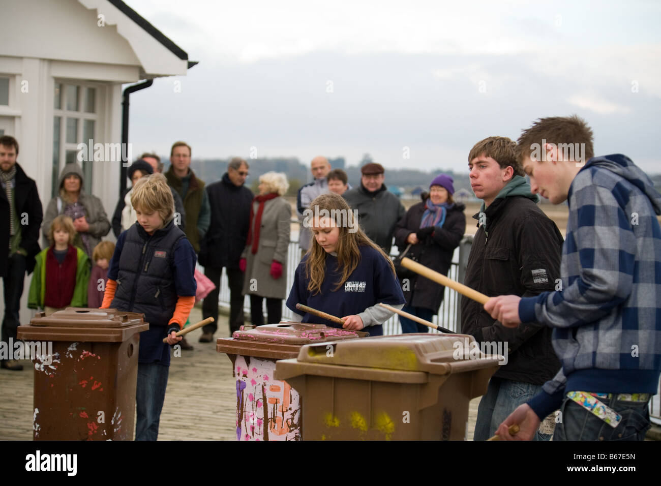 Una banda di giovani tamburellare sul pattumiere sul molo, Southwold, Suffolk, Inghilterra Foto Stock