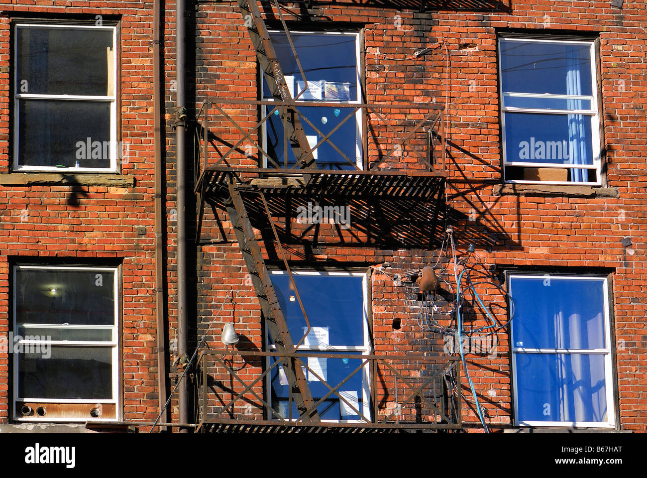 Edificio in mattoni con finestre e le scale di acciaio al di fuori Foto Stock