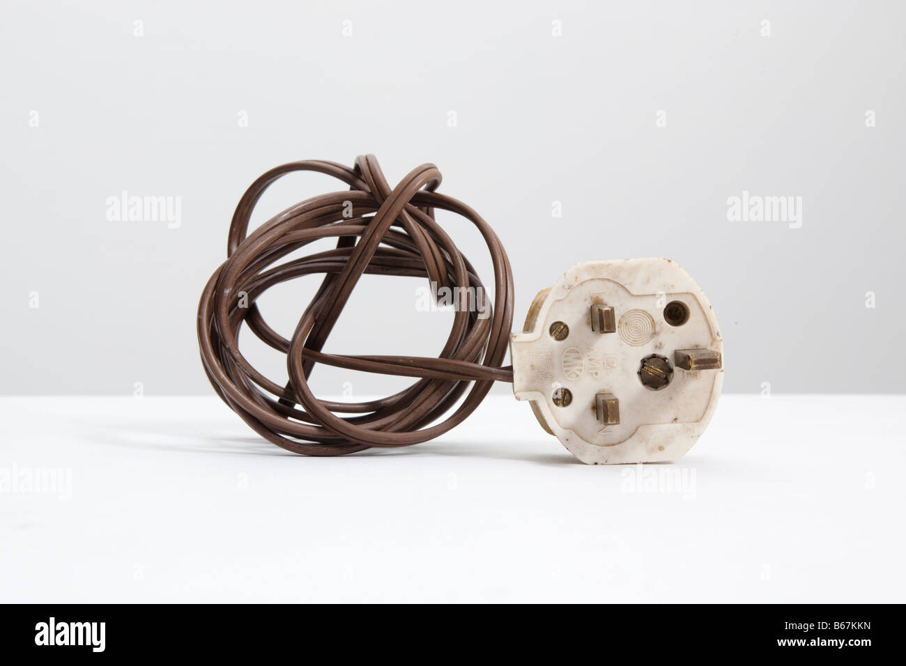 Vecchio bianco , inglese standard 13 amp spina elettrica e la bobina di marrone flex Foto Stock