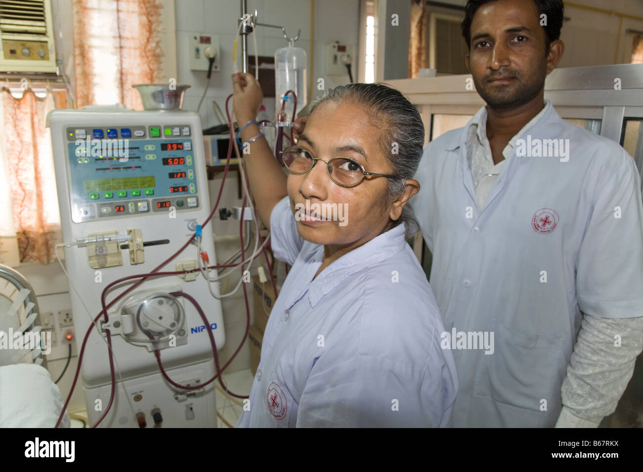 Gli infermieri con una macchina di dialisi nel reparto di nefrologia del Nuovo Ospedale Civile. Surat. Il Gujarat. India. Foto Stock