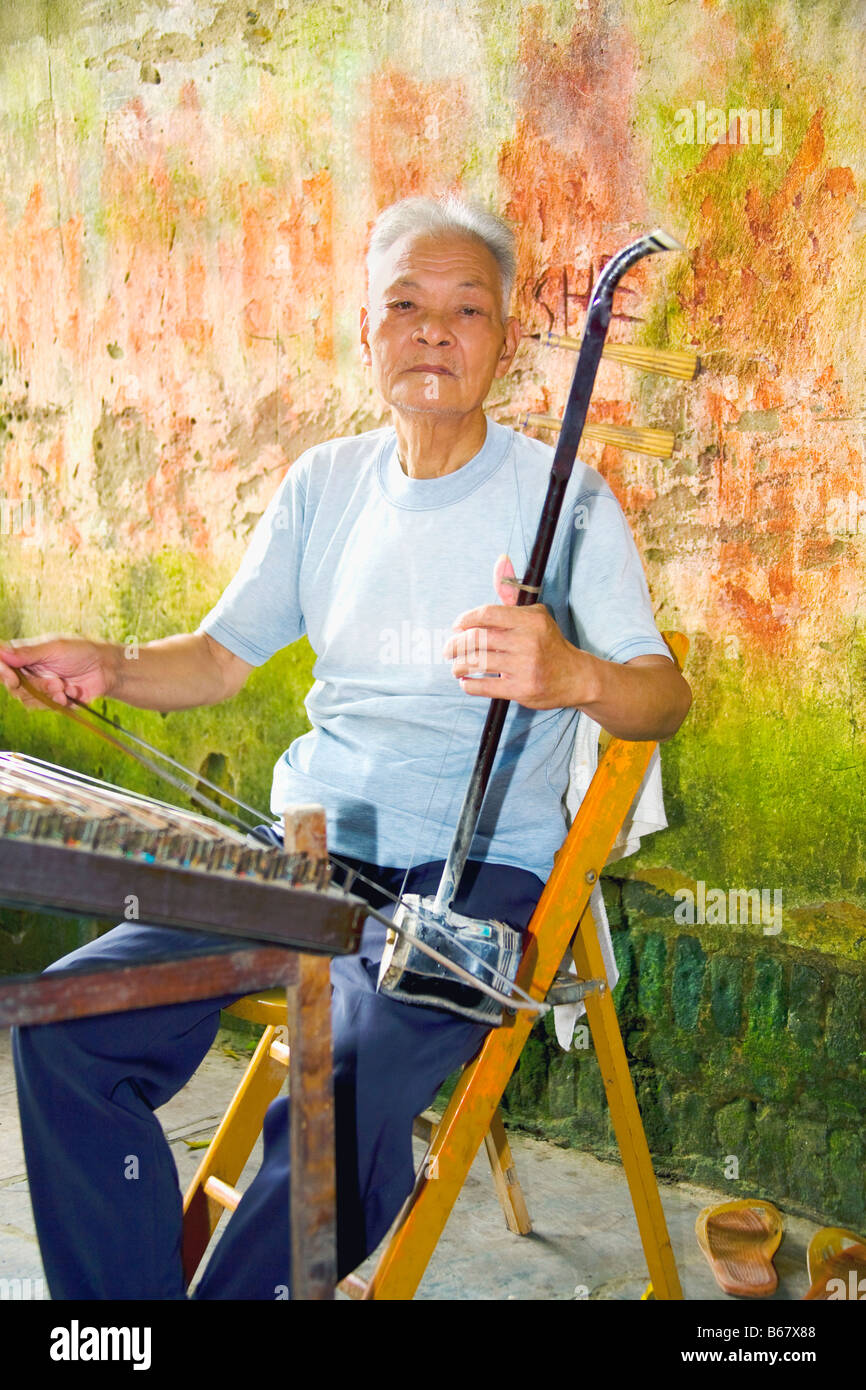 Senior uomo giocando erhu, Fuli Village, Yangshuo, provincia di Guangxi, Cina Foto Stock