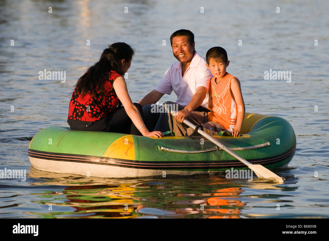 Il padre e la madre con un bambino di riga barca nel parco Xiwuzhumuqinqi Inner Mongolia Cina Foto Stock