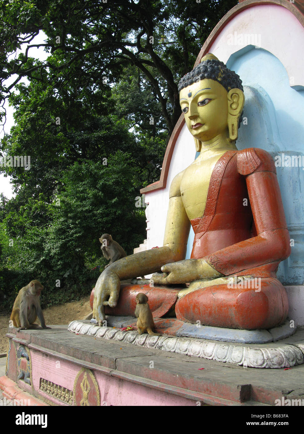 Macachi Rhesus (macaca mulatta) riprodurre sulla statua di Buddha a Swayambhunath stupa buddisti (aka Monkey Temple), Kathmandu, Bagmati, Himalaya, Nepal, Asia Foto Stock