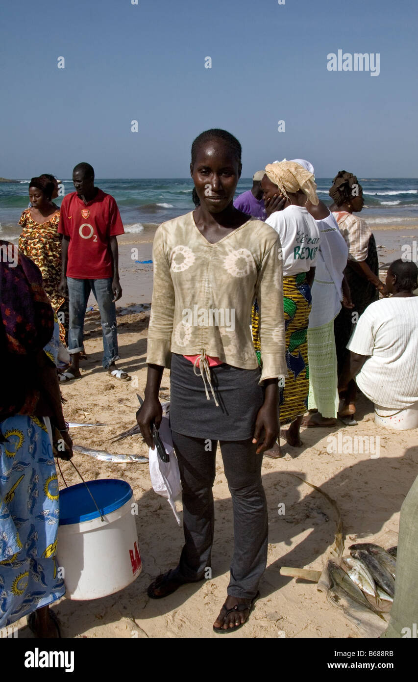 Donna acquisto appena sbarcato pesce al mercato del pesce sulla spiaggia di Yoff Dakar in Senegal Foto Stock