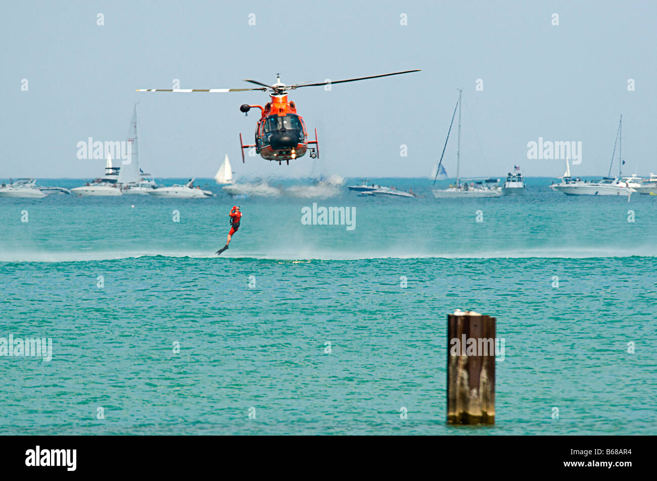 Stati Uniti Coast Guard elicottero & barca di salvataggio / sollevamento nuotatore di salvataggio al di fuori dell'acqua Foto Stock