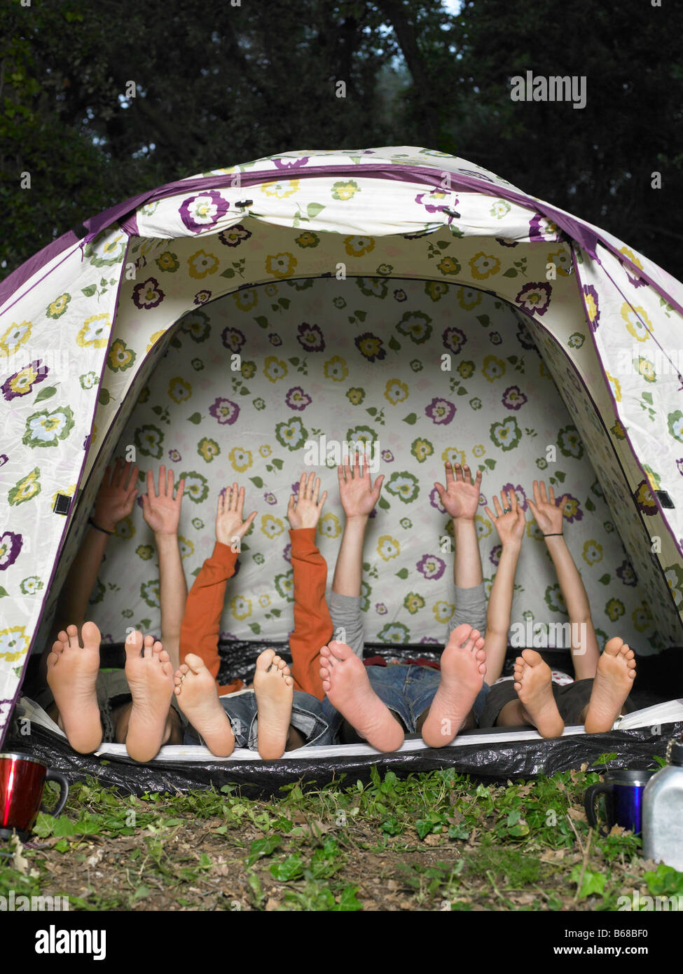 Quattro amici che allunga in tenda Foto Stock