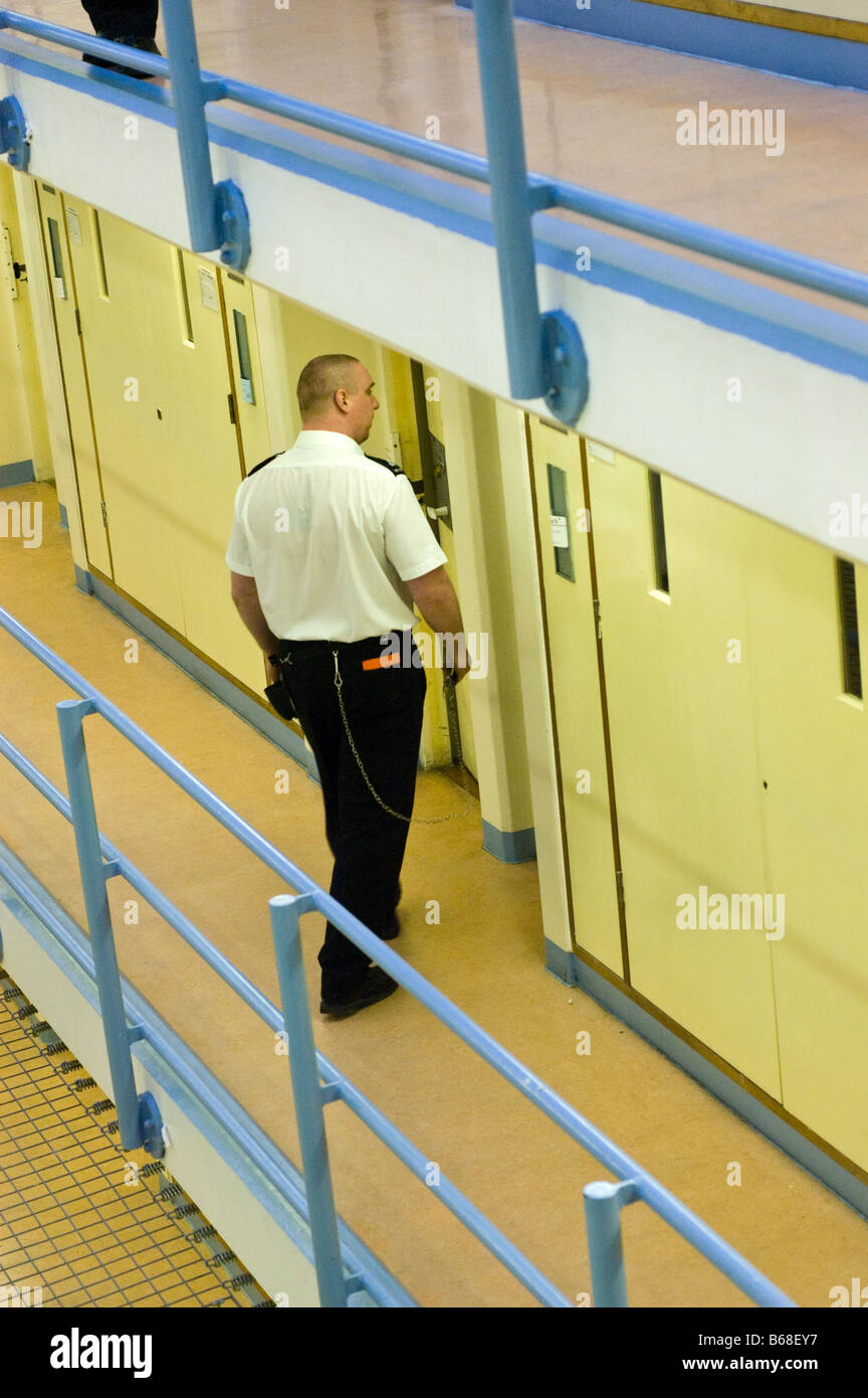 Personale carcerario verifica di una cella su un atterraggio Foto Stock