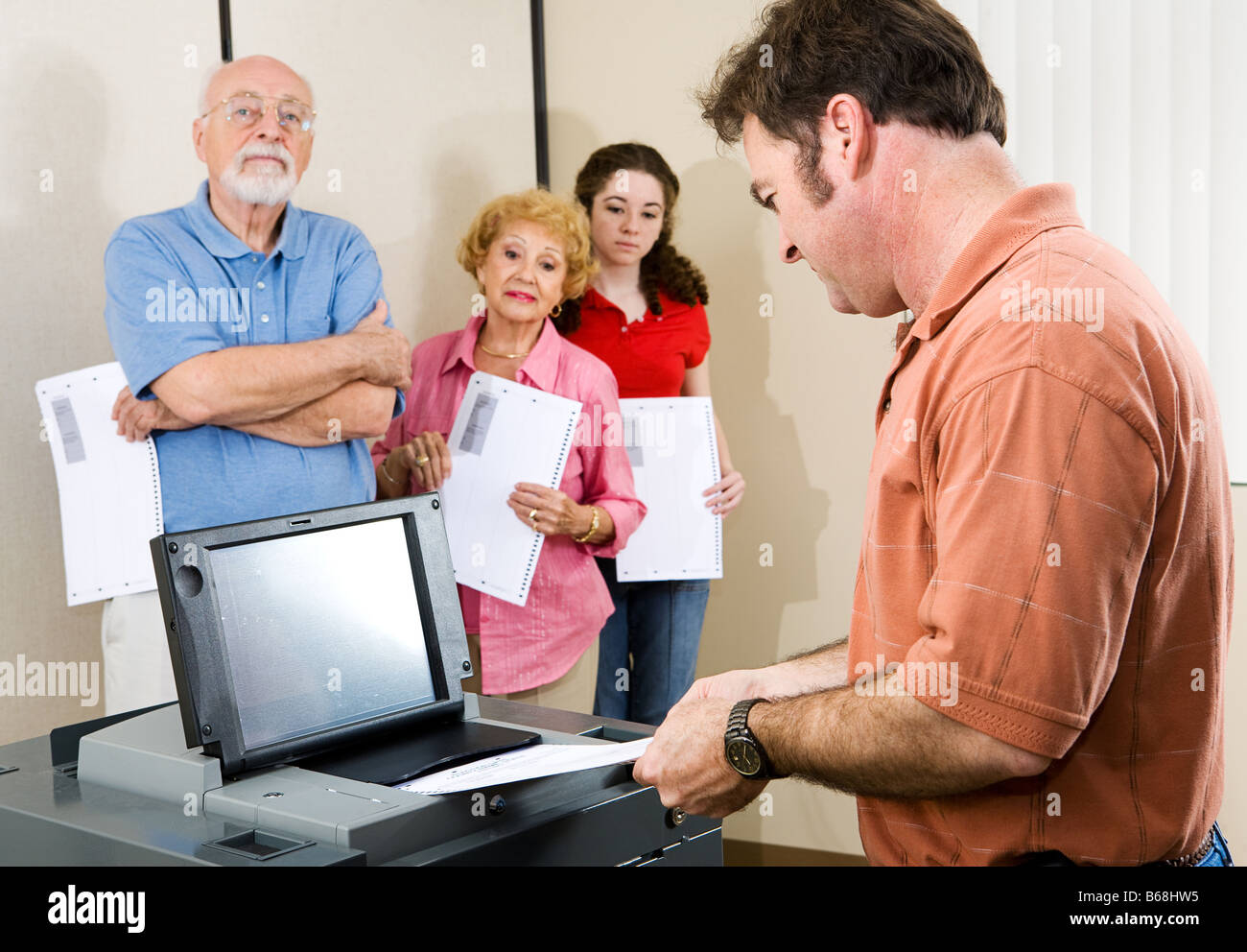 Adulto Uomo alimentando il suo scrutinio elettorale in scansione ottica macchina di voto Foto Stock