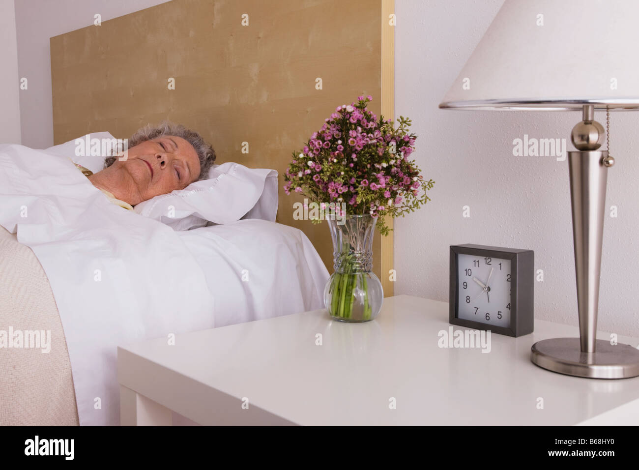 Senior donna dorme nel letto Foto Stock