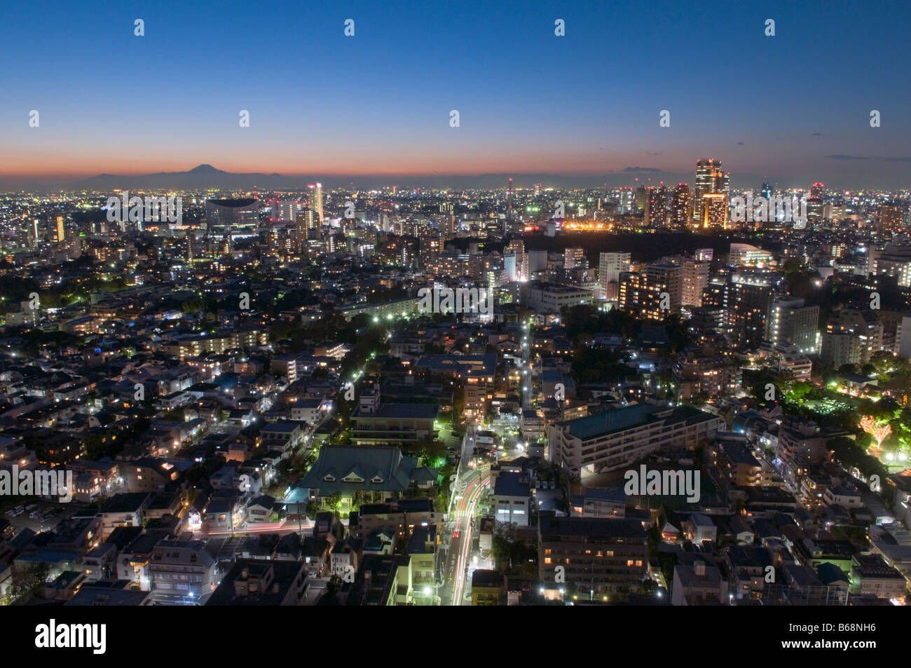 Lo skyline di Tokyo con il Monte Fuji in lontananza al tramonto Foto Stock
