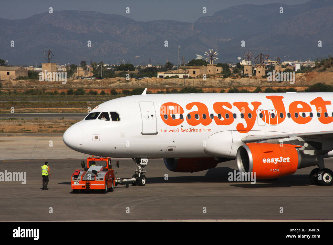 Easyjet aerei Boeing essendo spinto al di fuori della zona di parcheggio mediante l'aviosuperficie veicolo di servizio pronto a decollare. Foto Stock