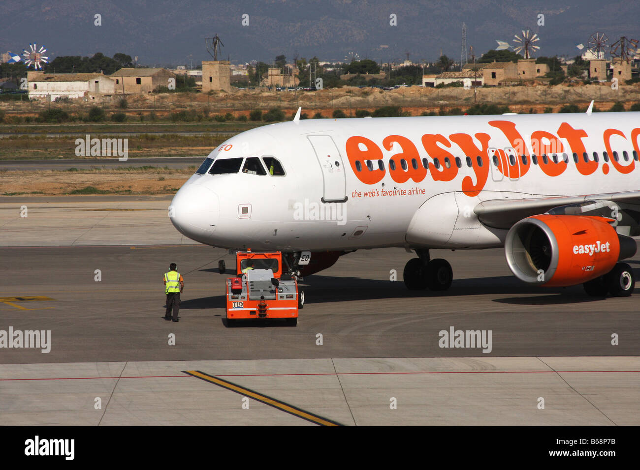 Easyjet aerei Boeing essendo spinto al di fuori della zona di parcheggio mediante l'aviosuperficie veicolo di servizio pronto a decollare. Foto Stock