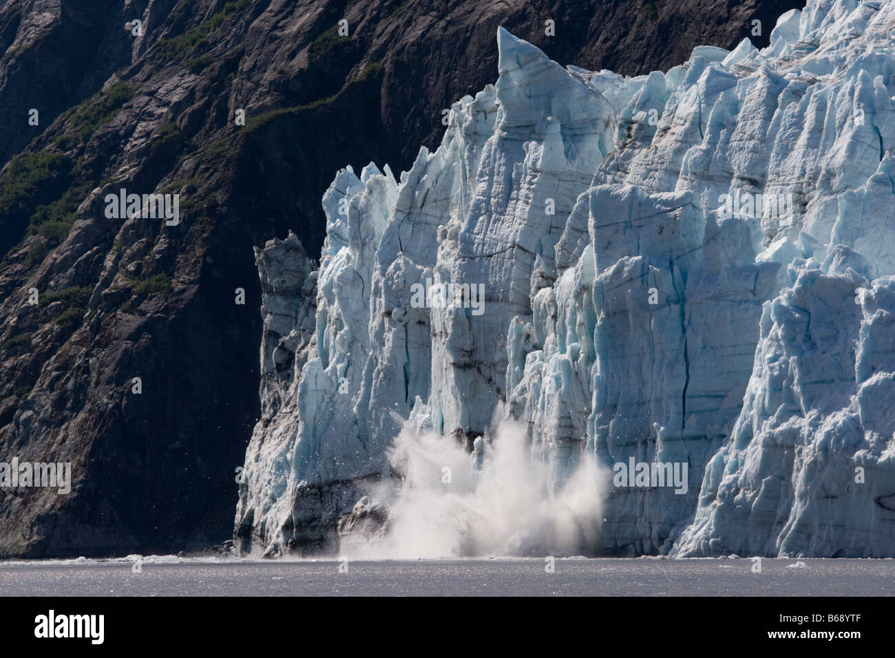 Stati Uniti d'America Alaska Parco Nazionale di Glacier Bay iceberg calve) con esplosivo splash dal ghiacciaio Margerie Tarr in ingresso su mattinata estiva Foto Stock